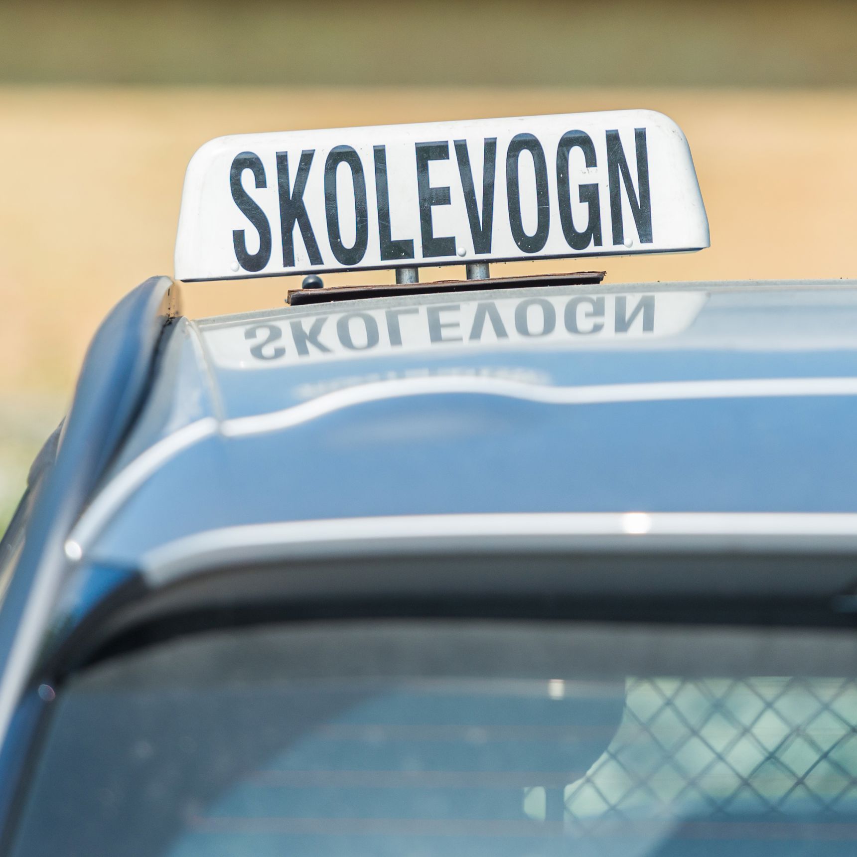 Bil med skolevogns skilt på taget