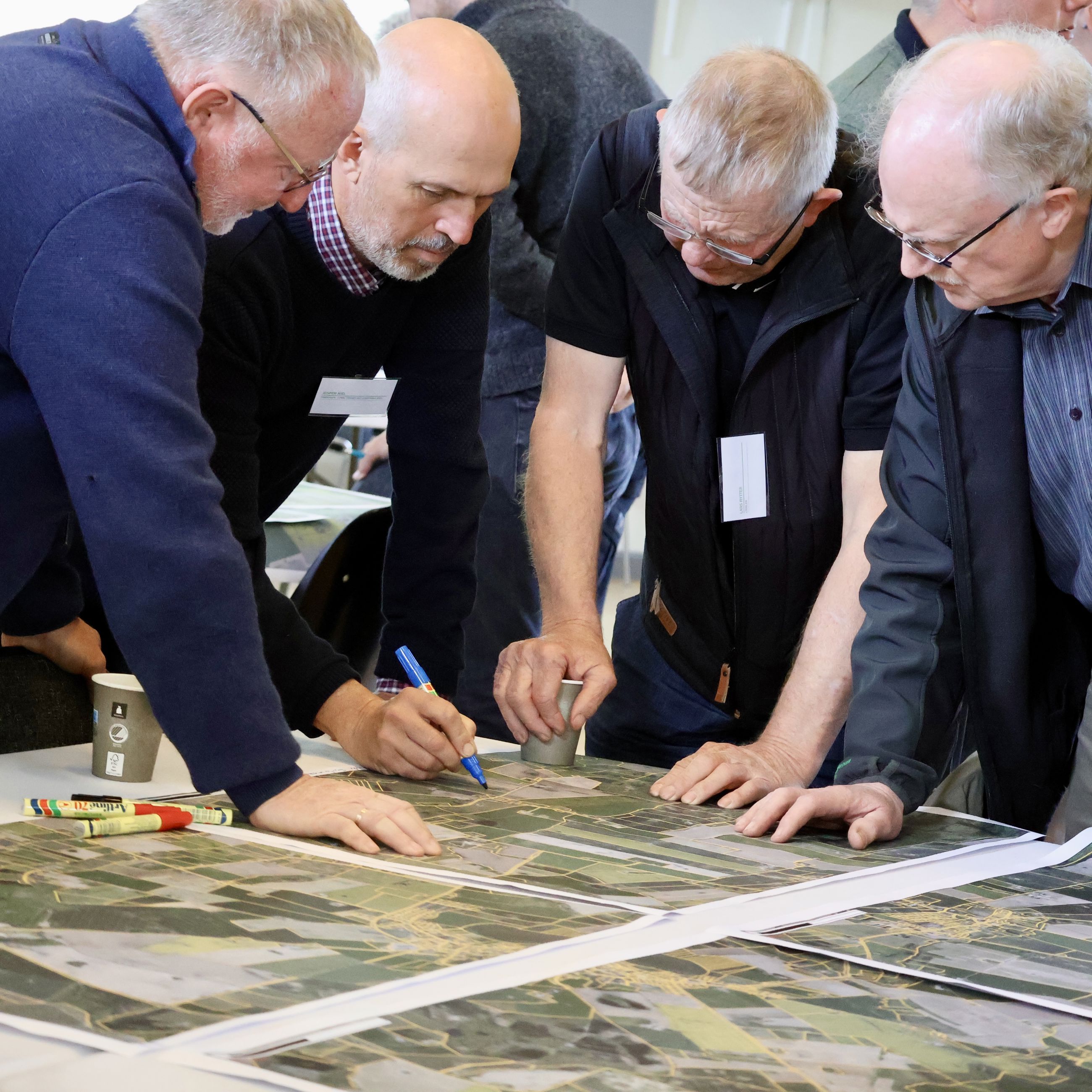 Lodsejere og formand for treparten kigger på matrikelkort