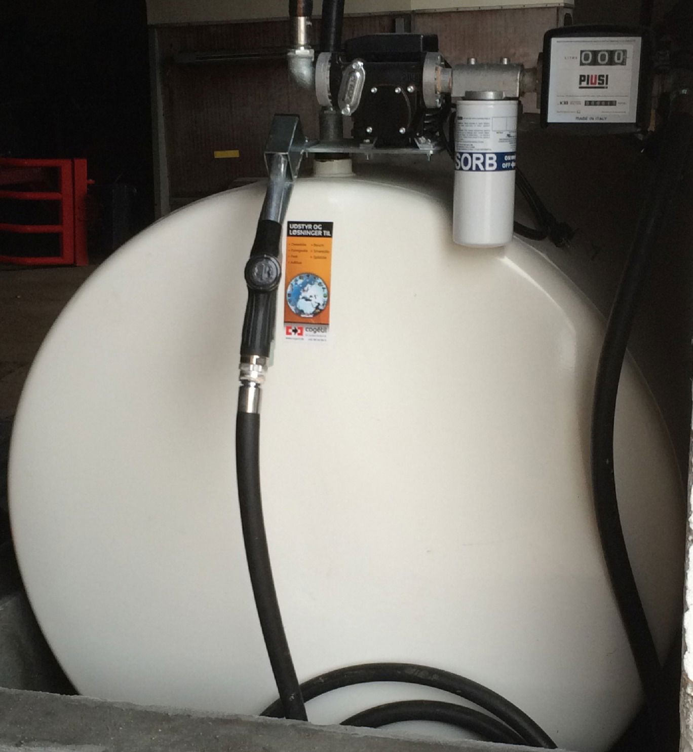 Hvid olietank set fra enden med slangen