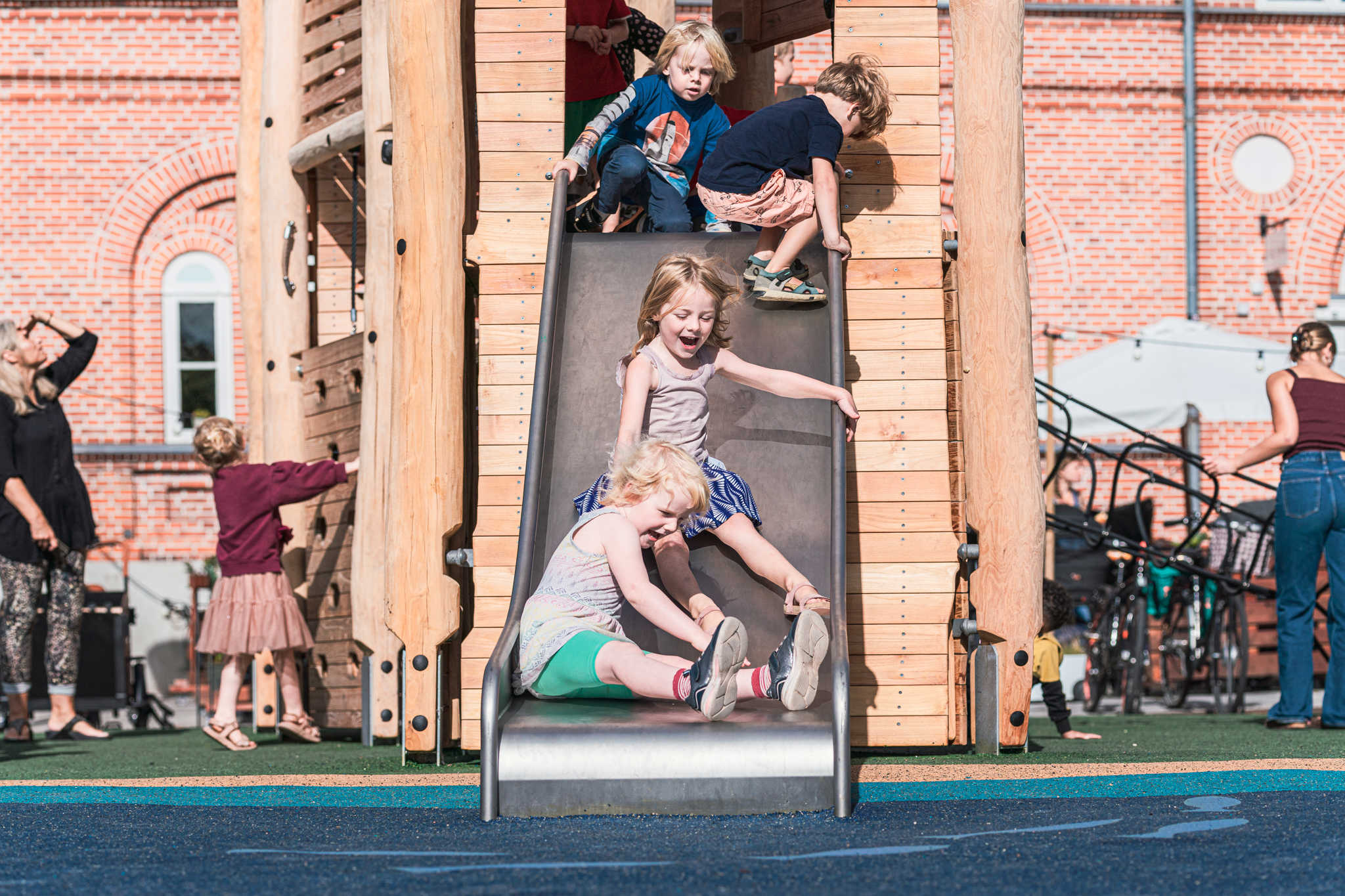 Børn rutcher ned af en rutchebane på en legeplads