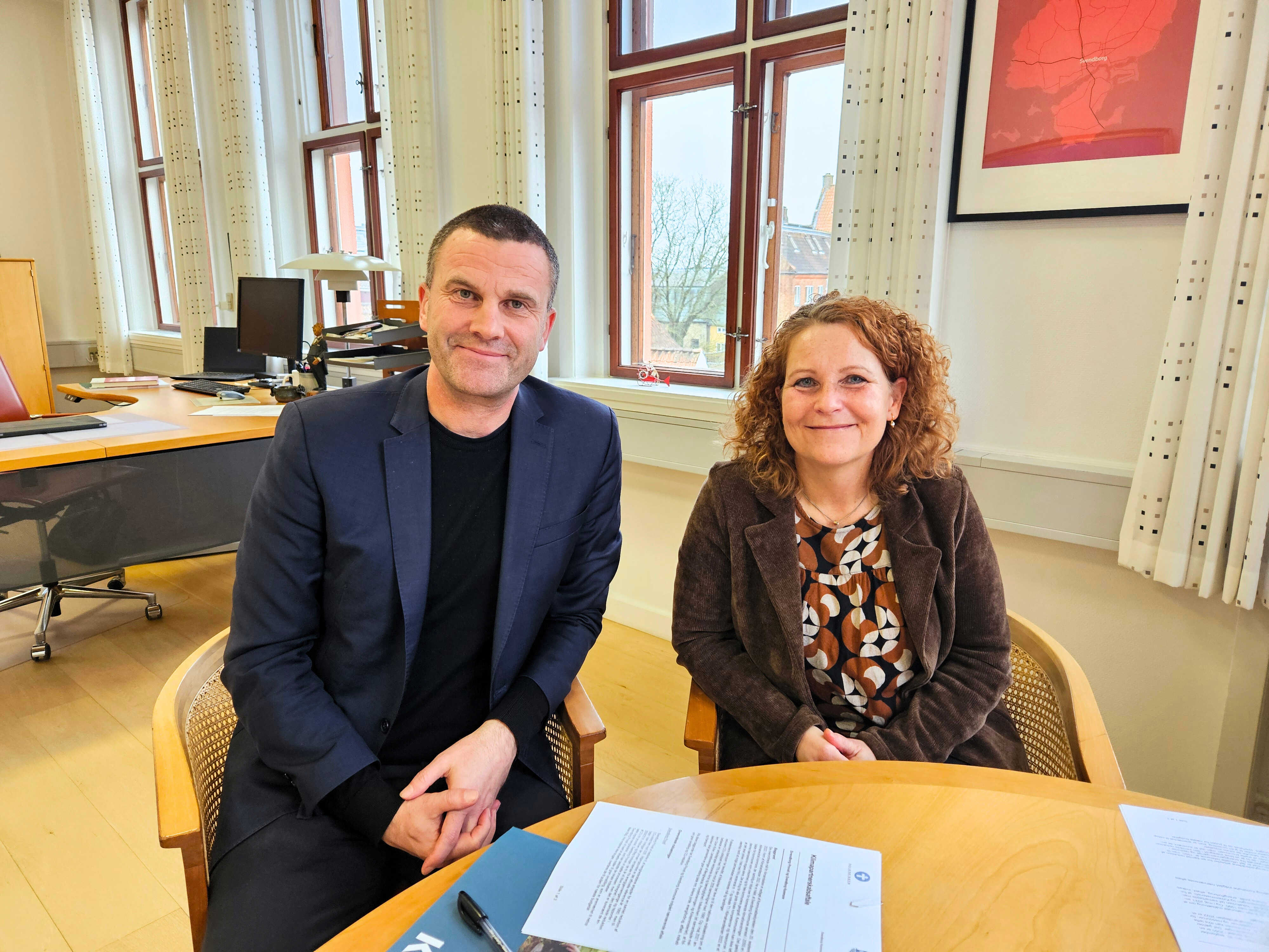 Borgmester Bo Hansen og Provst Bente Holdgaard har netop underskrevet en klimapartnerskabsaftale. De smiler til kameraet.