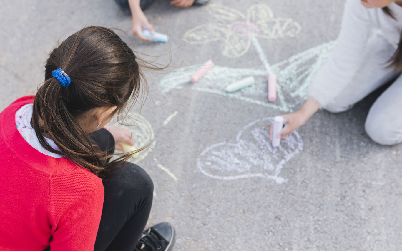 Børn tegner med kridt i skolegård