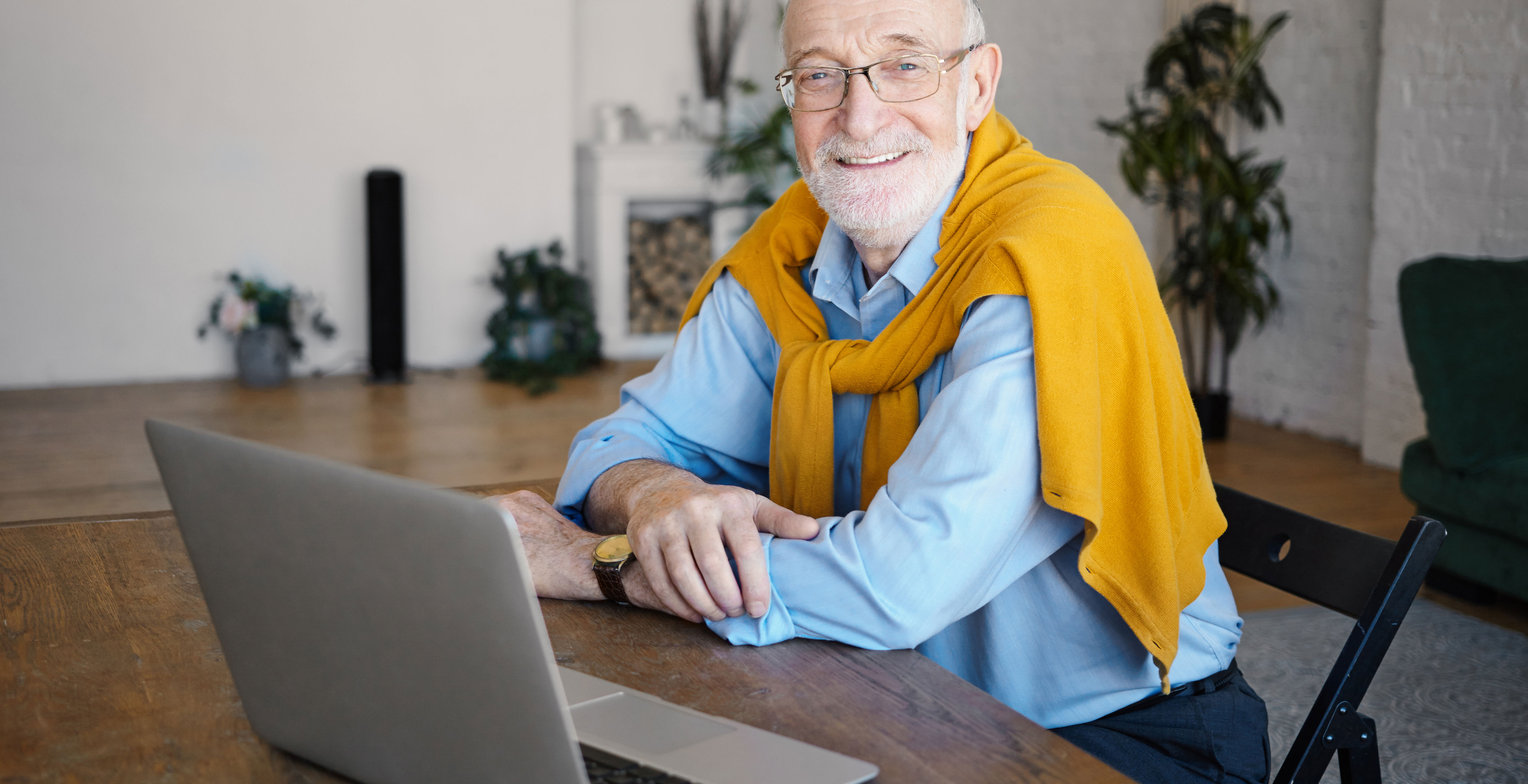 Ældre mand sidder foran en bærbar computer