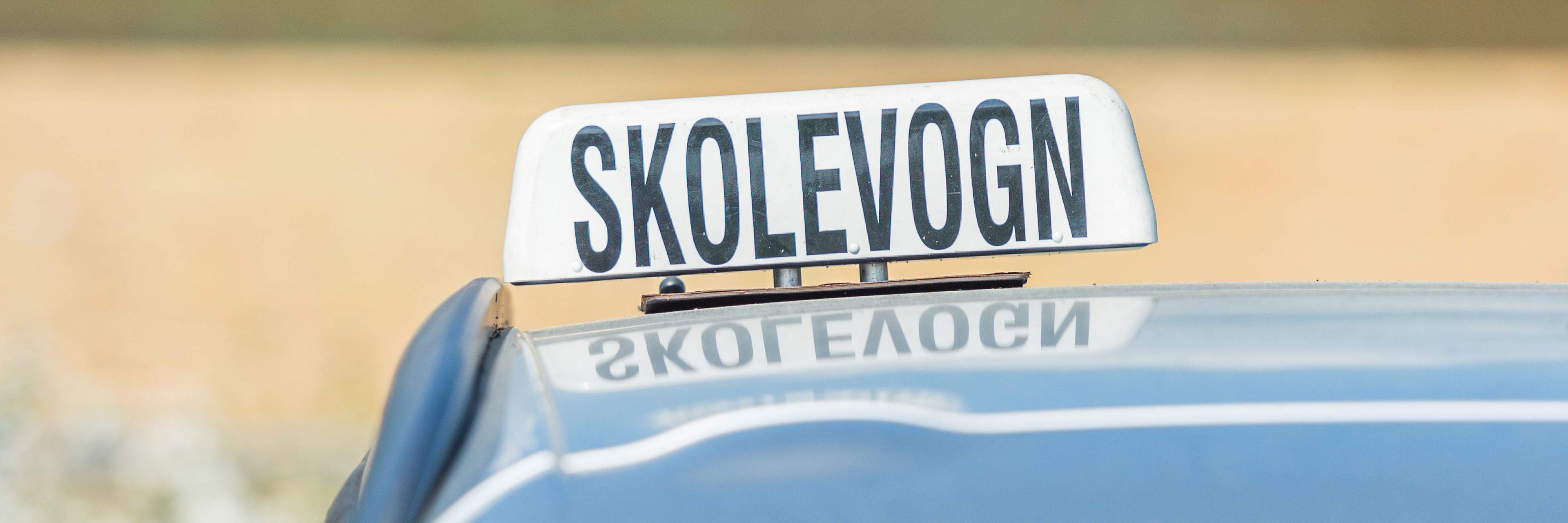 Bil med skolevogns skilt på taget