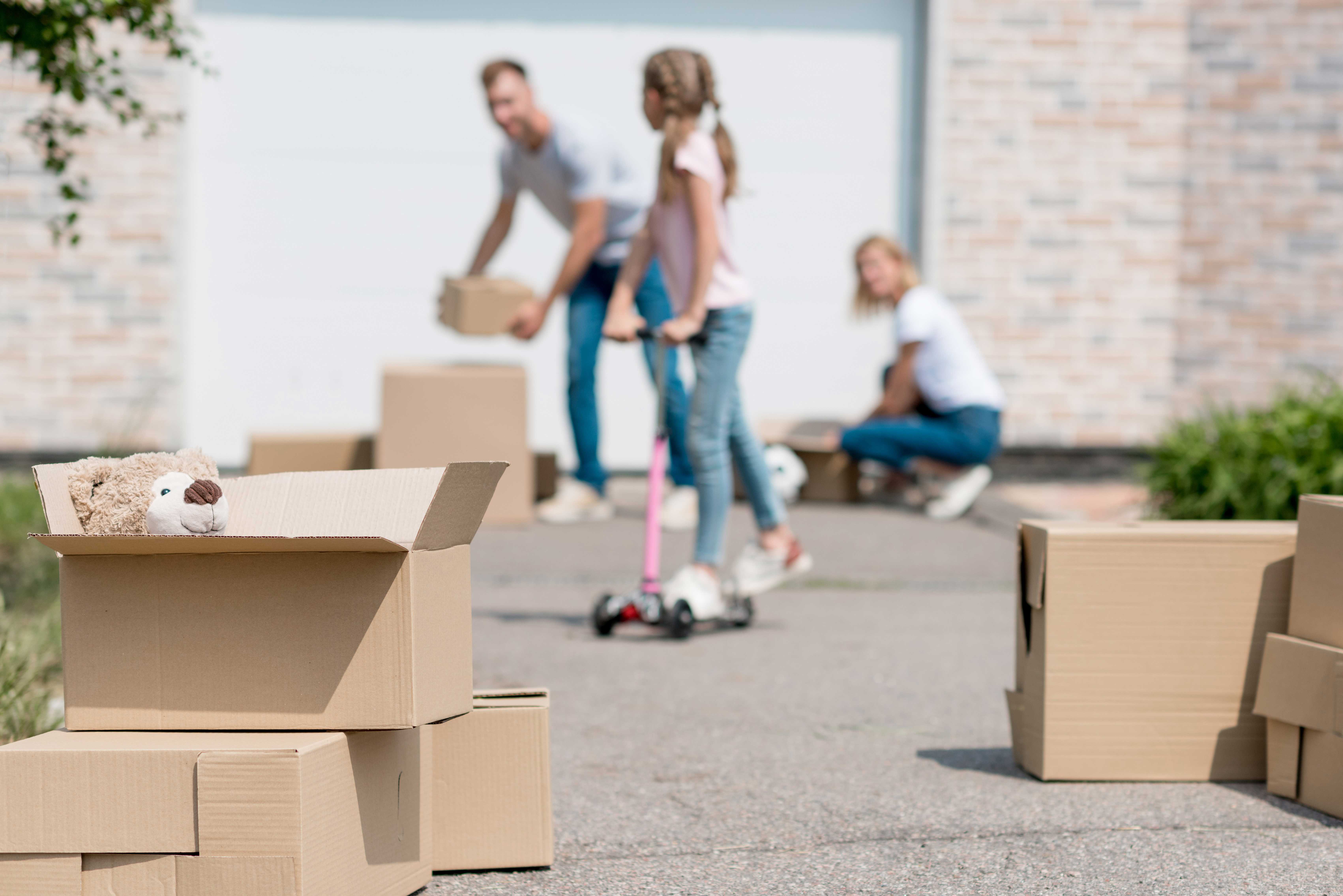 Familie med flyttekasser i indkørsel