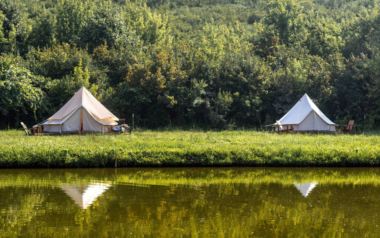 Grønt landskab med to glampingtelte