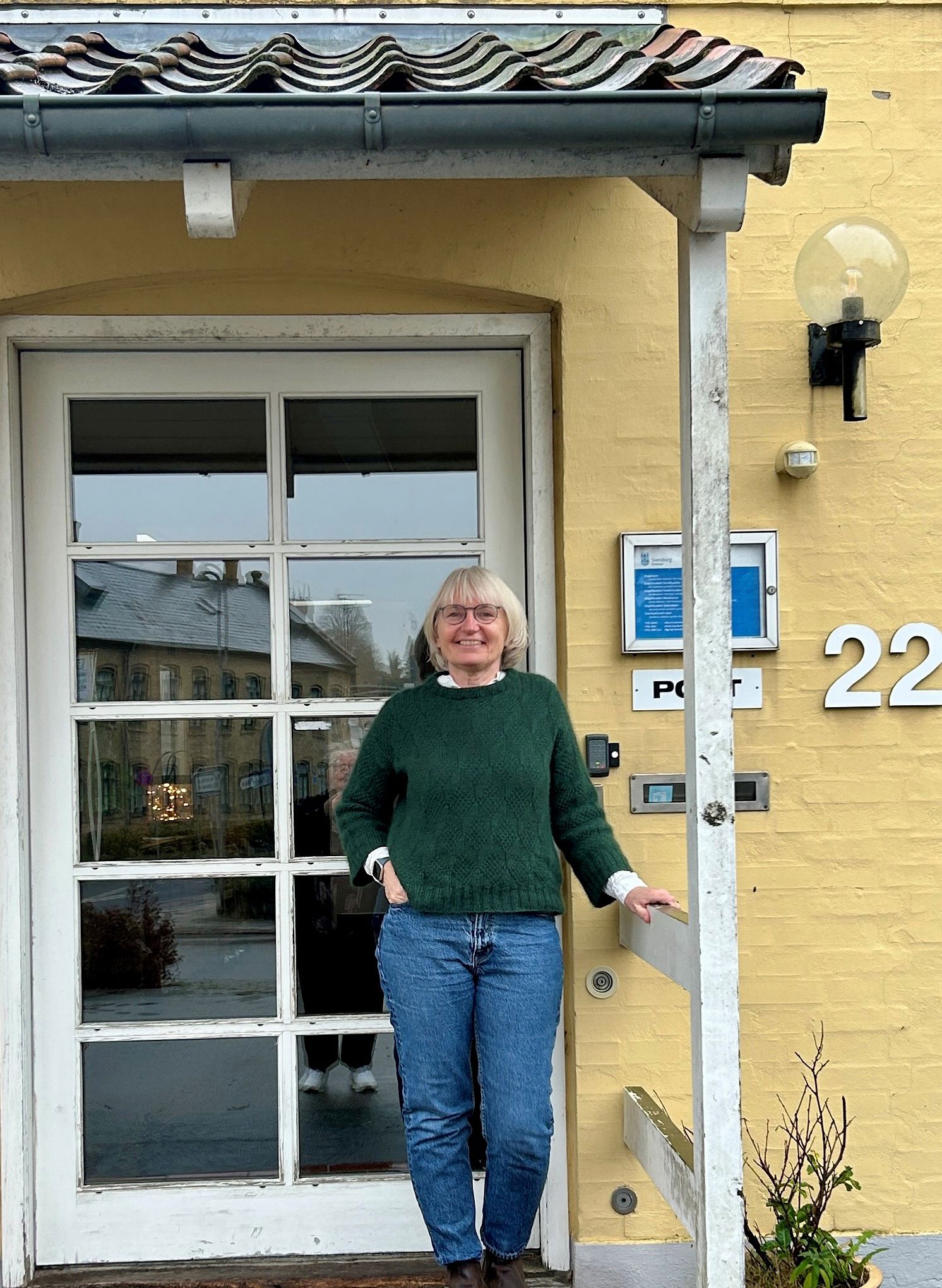 Kvinde står foran indgangsdør