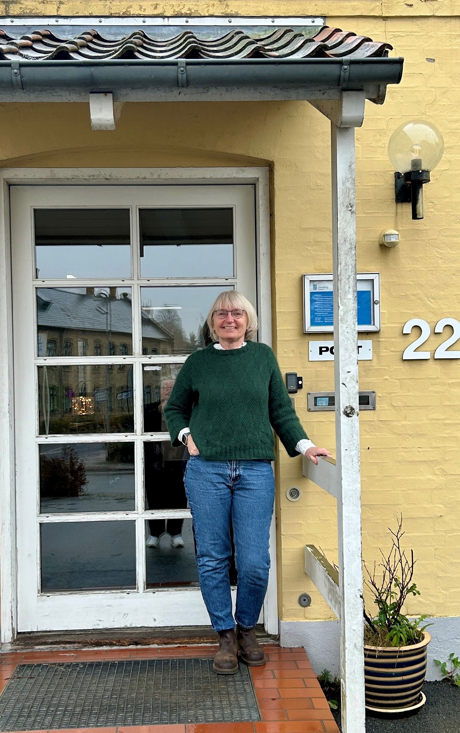 Kvinde står foran indgangsdør